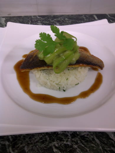 Filet de bar poêlé accompagné d'un gâteau de riz à la coriandre, rubbans de concombre et bouillon Thaï